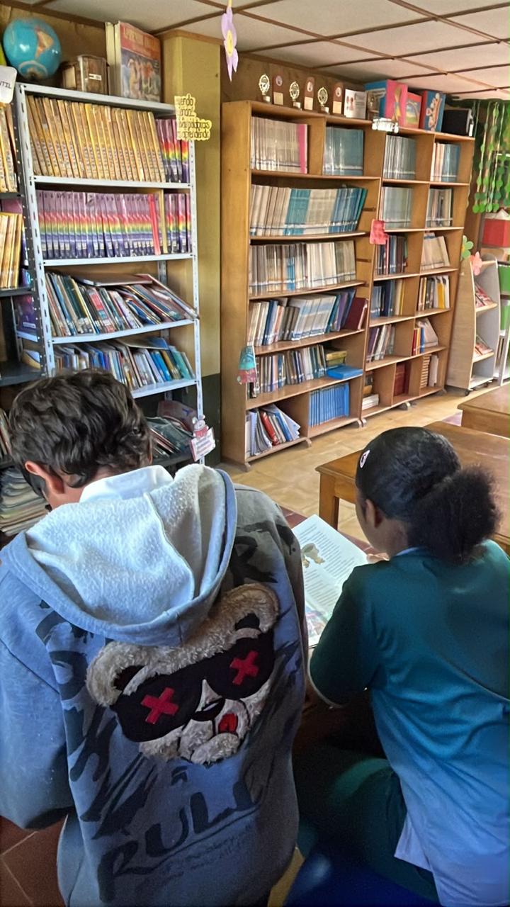 Estudiantes consultando libros en la biblioteca
